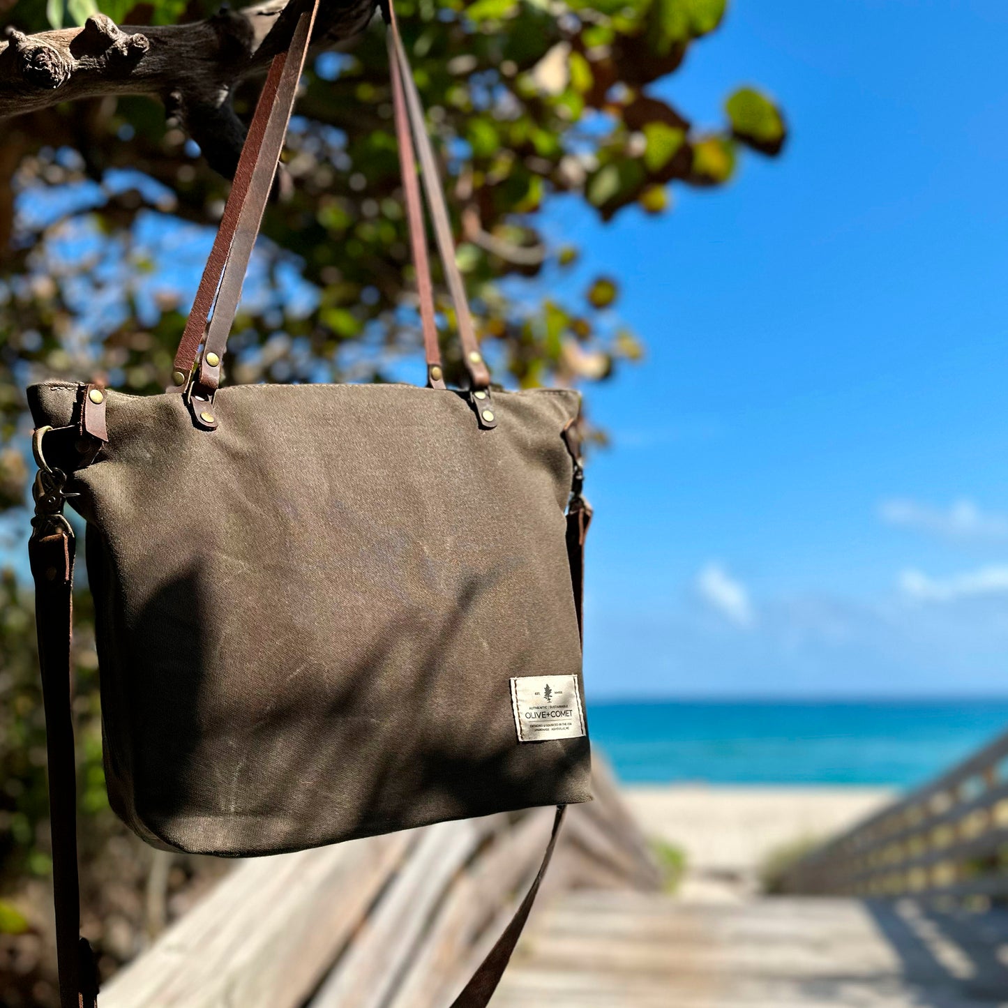 Detail of a Marquesa bag hanging from the sea grapes by the ocean