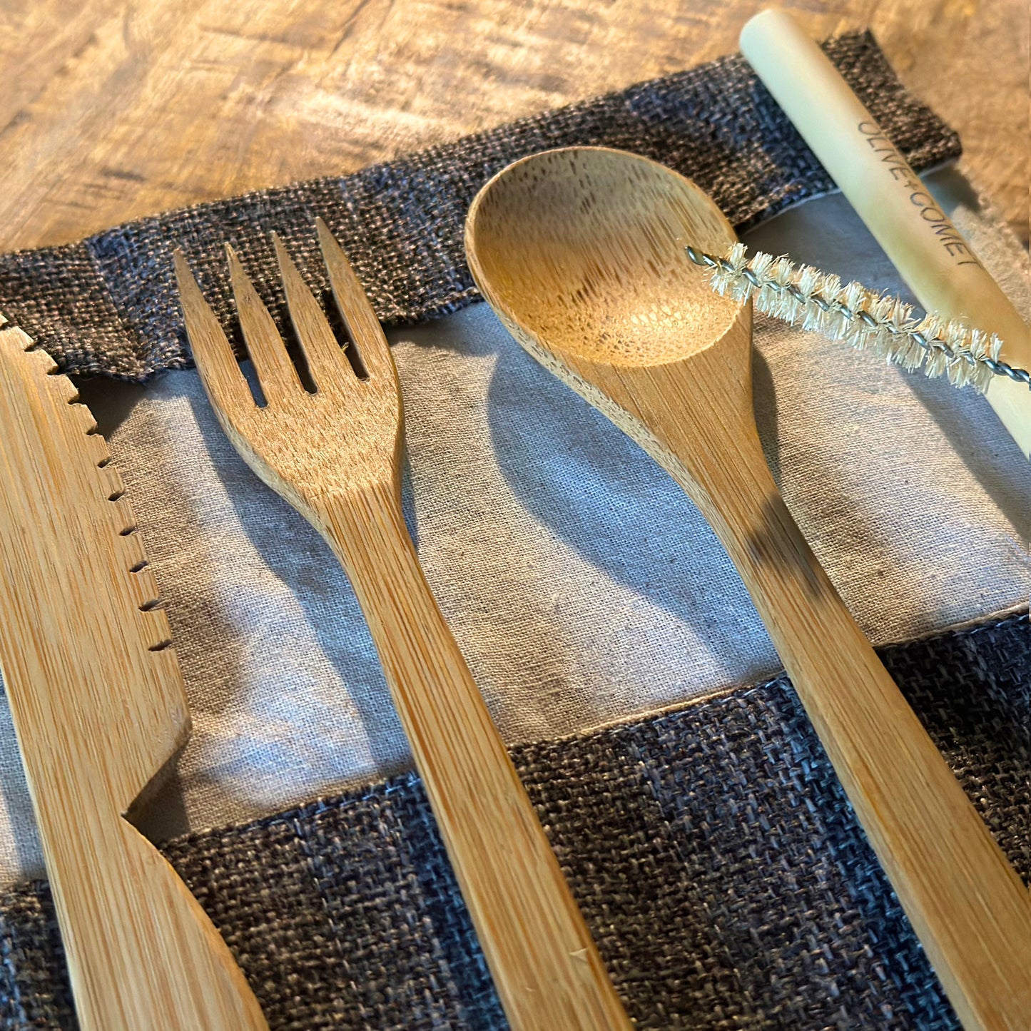A Sarita bamboo flatware set lies open on a mango wood table