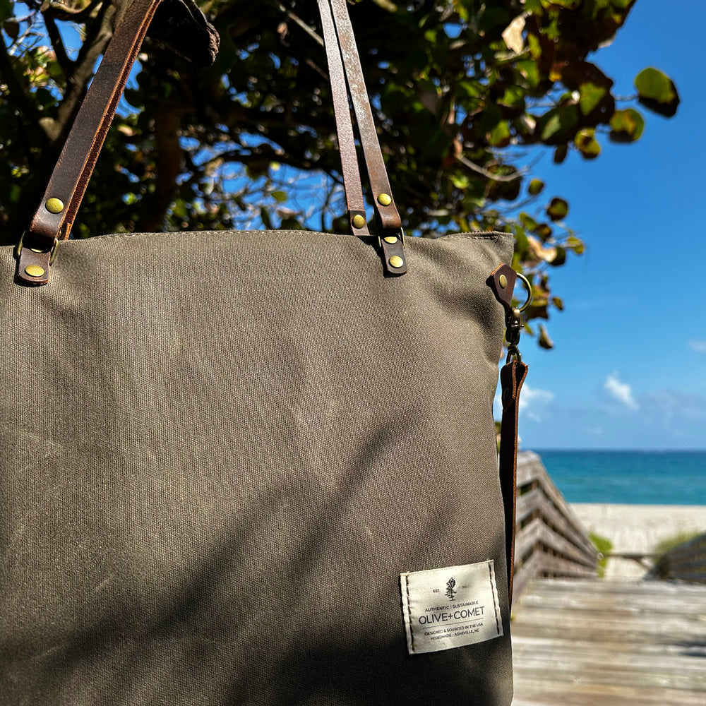 
                  
                    Detail of a Marquesa bag hanging from the sea grapes by the ocean
                  
                