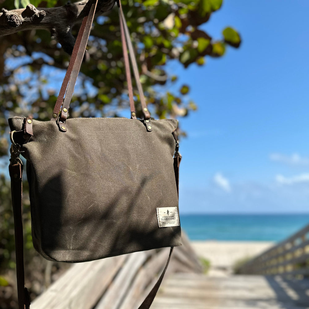 Detail of a Marquesa bag hanging from the sea grapes by the ocean