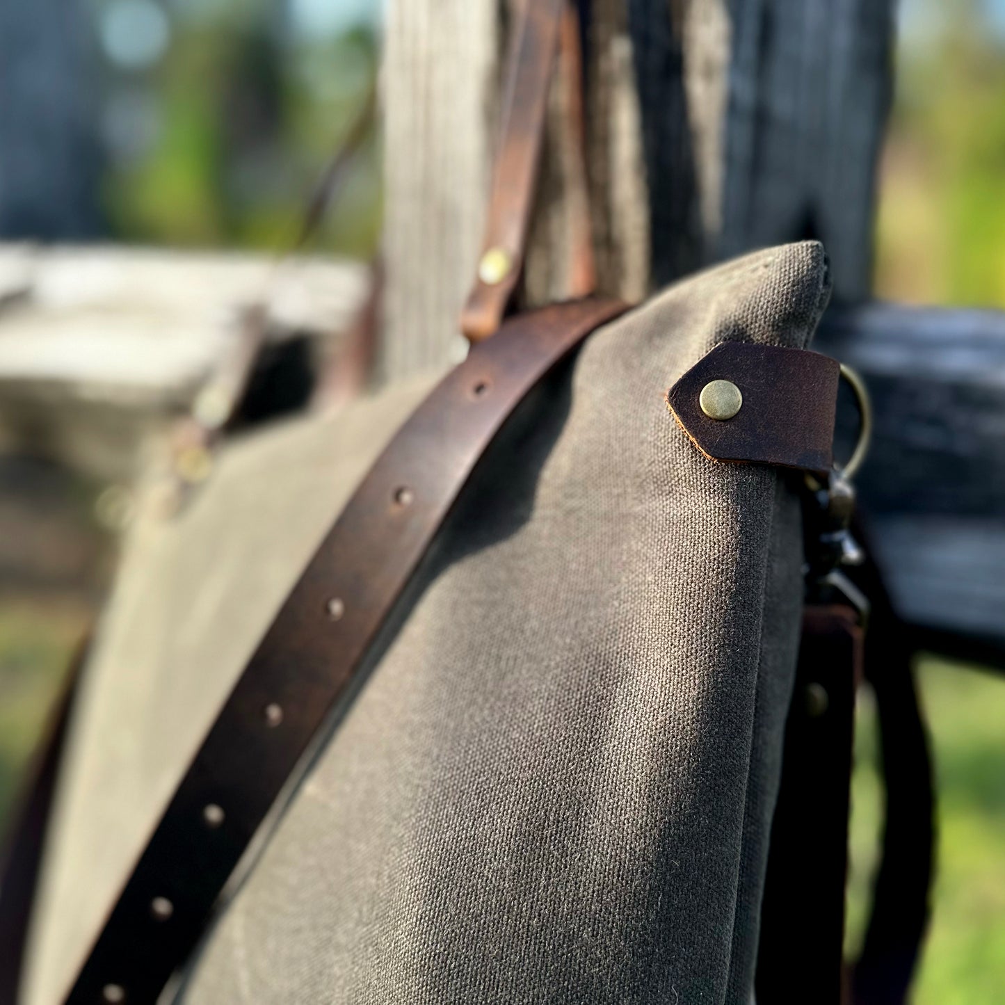 
                  
                    Detail of a Marquesa bag hanging on an old wooden fence
                  
                