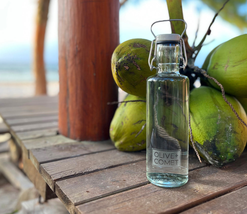 A plastic free & sustainable Hadley water bottle sits on a tiki bar by the ocean