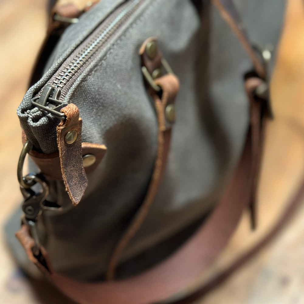 
                  
                    Detail photo of the Olive+Comet Marquesa bag showing the brass zipper and leather zipper pull
                  
                