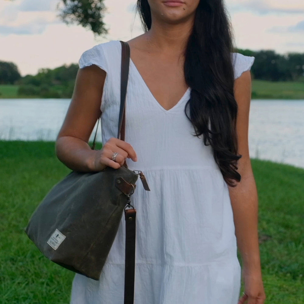 
                  
                    A woman in a white dress walks with a Marquesa bag on her shoulder
                  
                