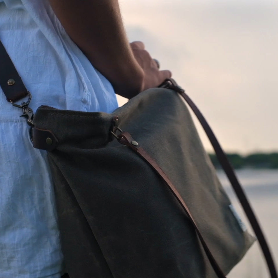 
                  
                    A woman walks along a pond with a Marquesa bag in weathered bark color slung on her shoulder
                  
                