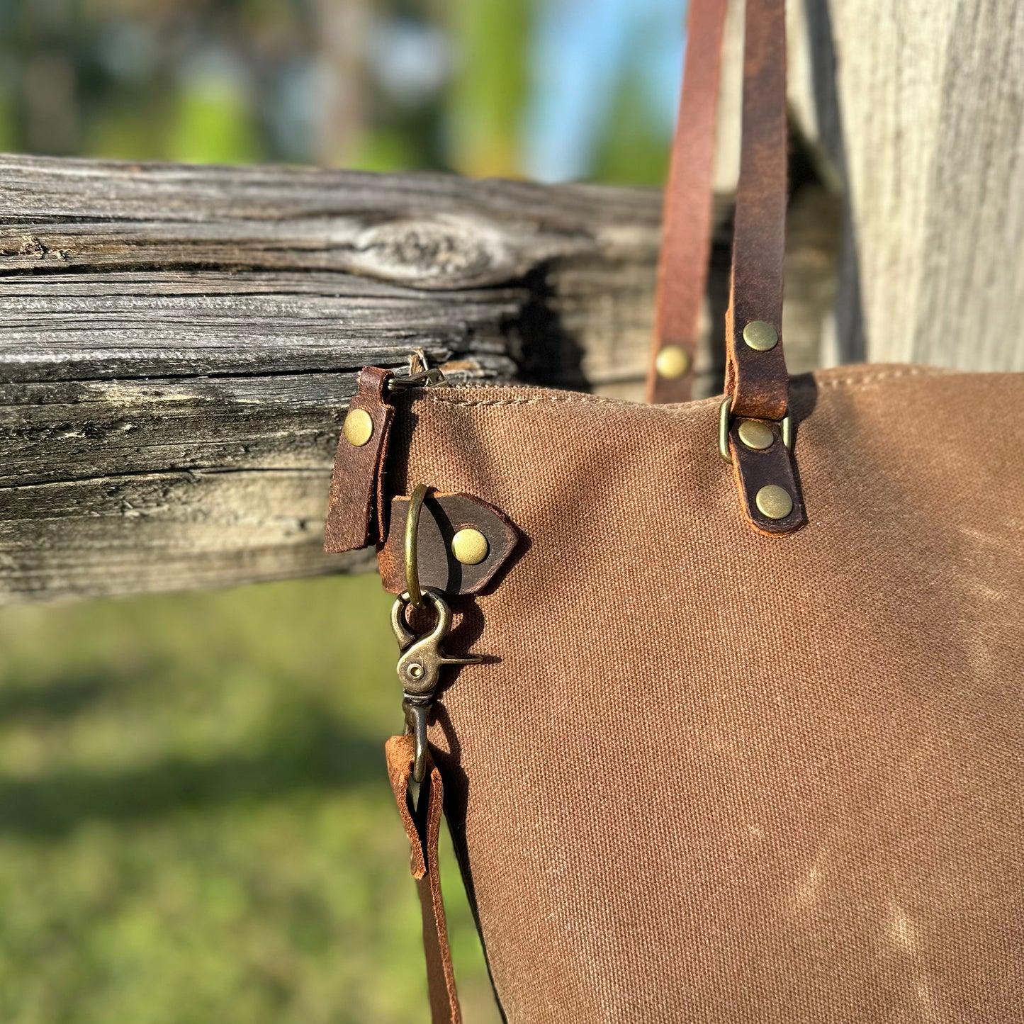 
                  
                    Detail of a Marquesa bag hanging on an old wooden fence
                  
                