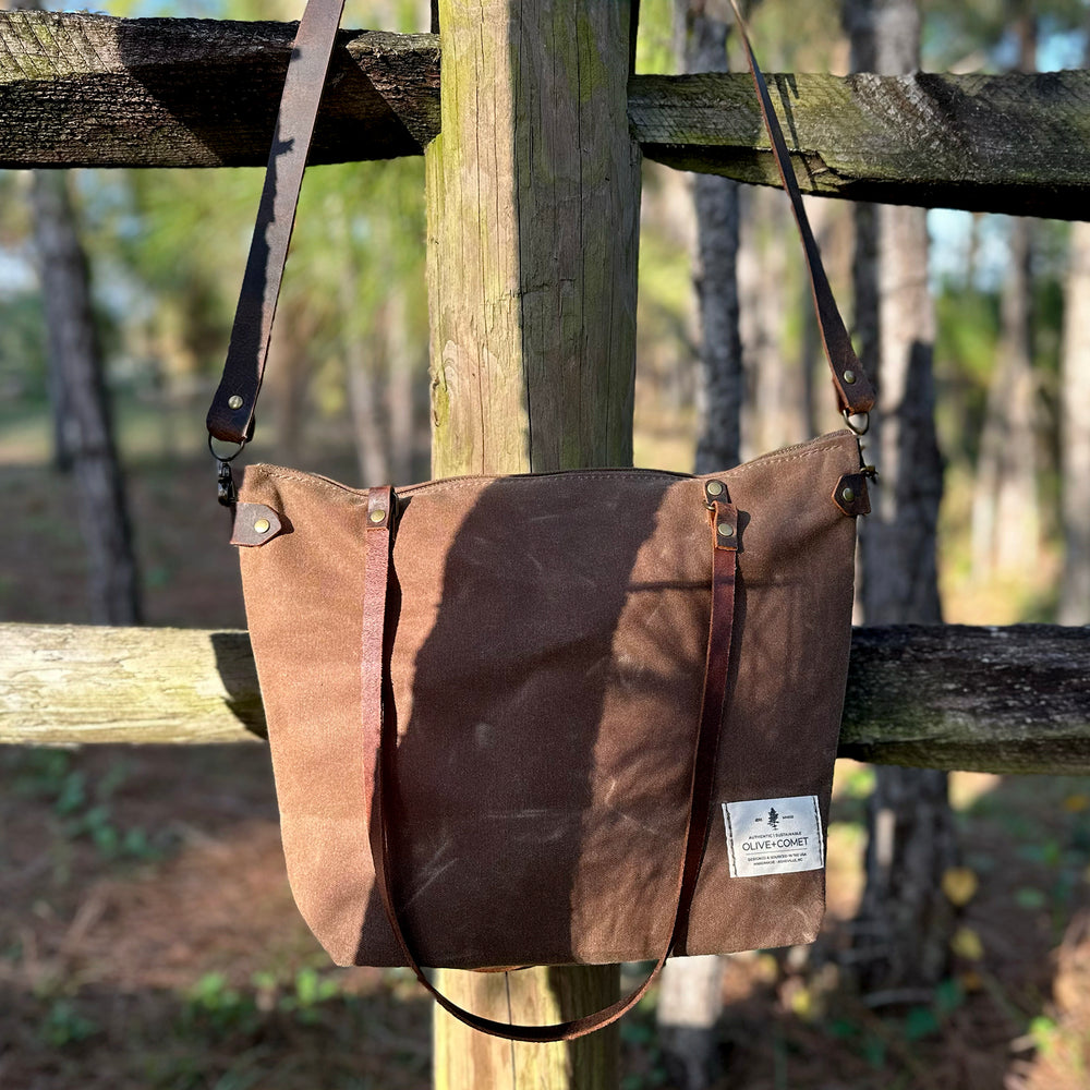 
                  
                    Detail of a Marquesa bag hanging on a weathered wooden fence
                  
                