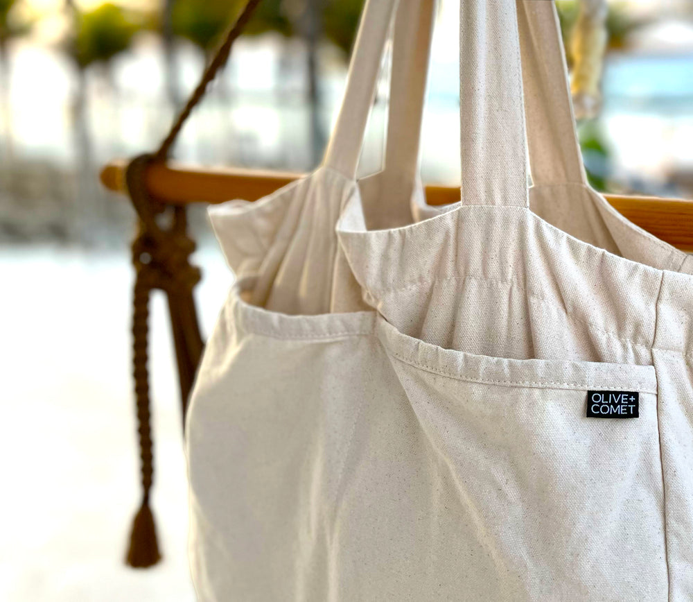 A Sonoma bag hangs on the corner of a hammock by the ocean