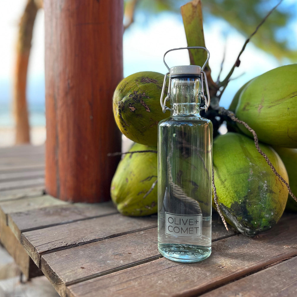 A plastic free and sustainable Hadley water bottle sits on a tiki bar by the ocean